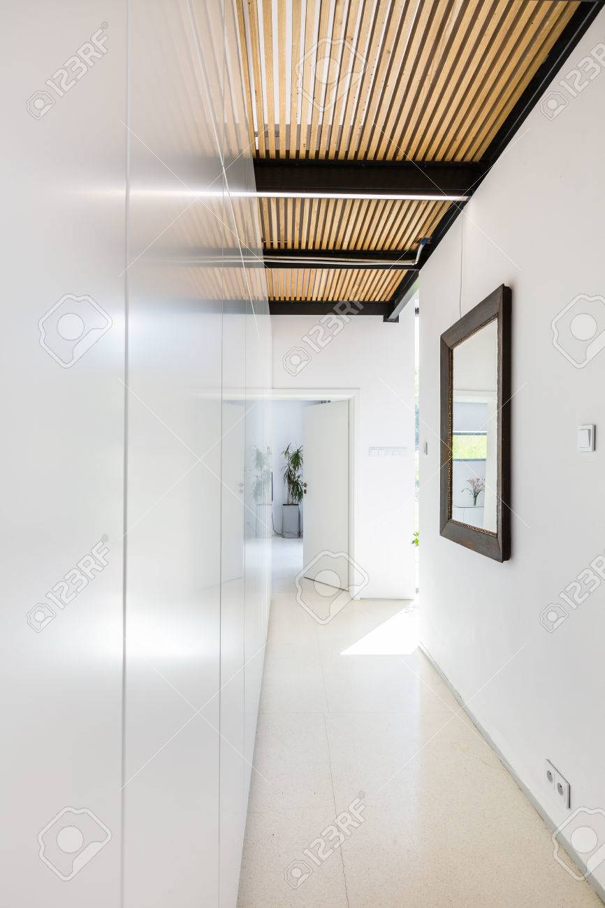 Wooden Board Ceiling In Narrow White Hall Interior Stock Photo