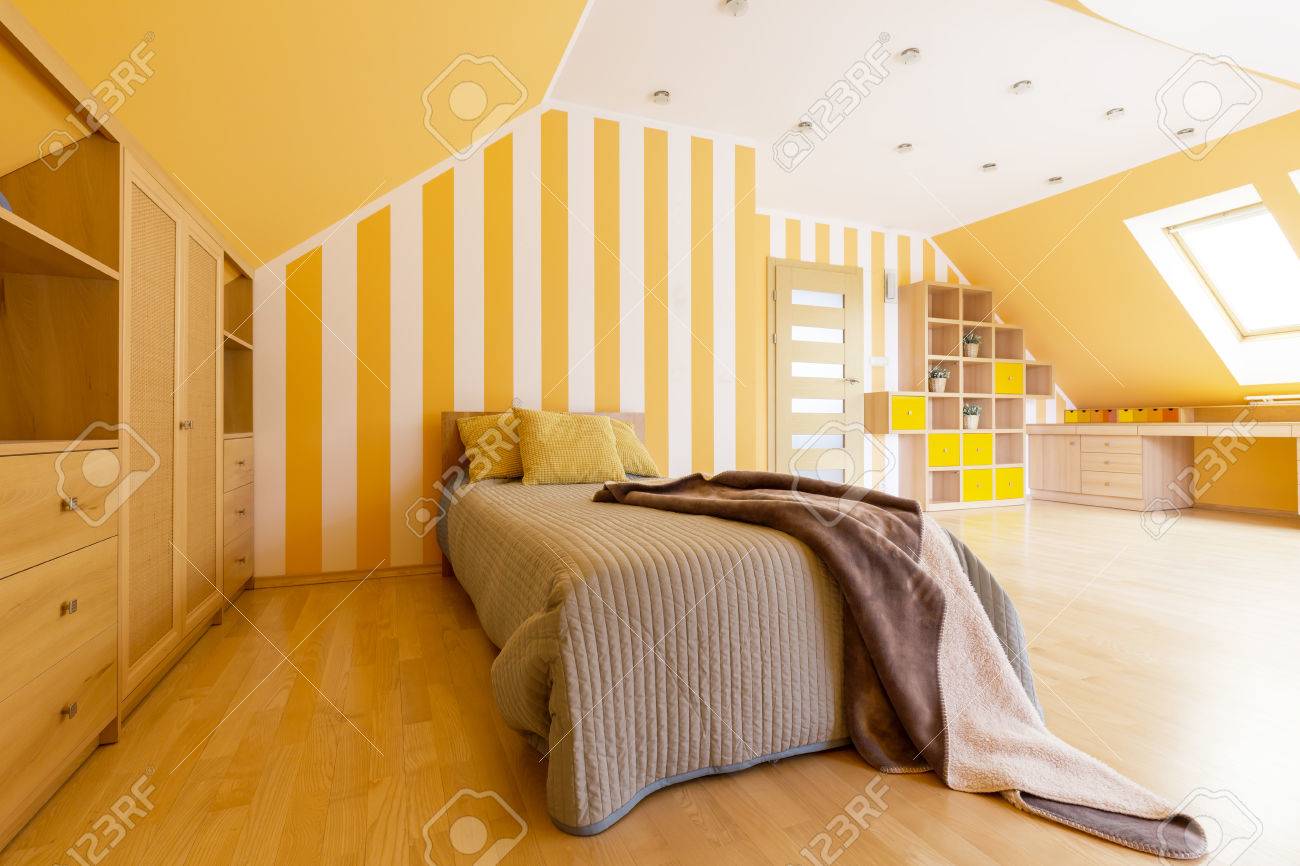 Shot Of A Spacious Modern Bedroom With Orange Walls