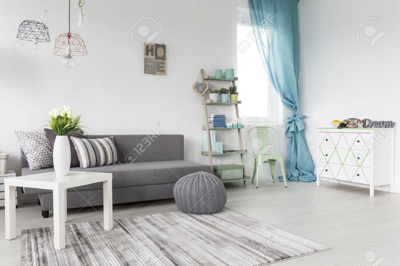 Grey Living Room With A Mint Curtains And White Walls Stock Photo