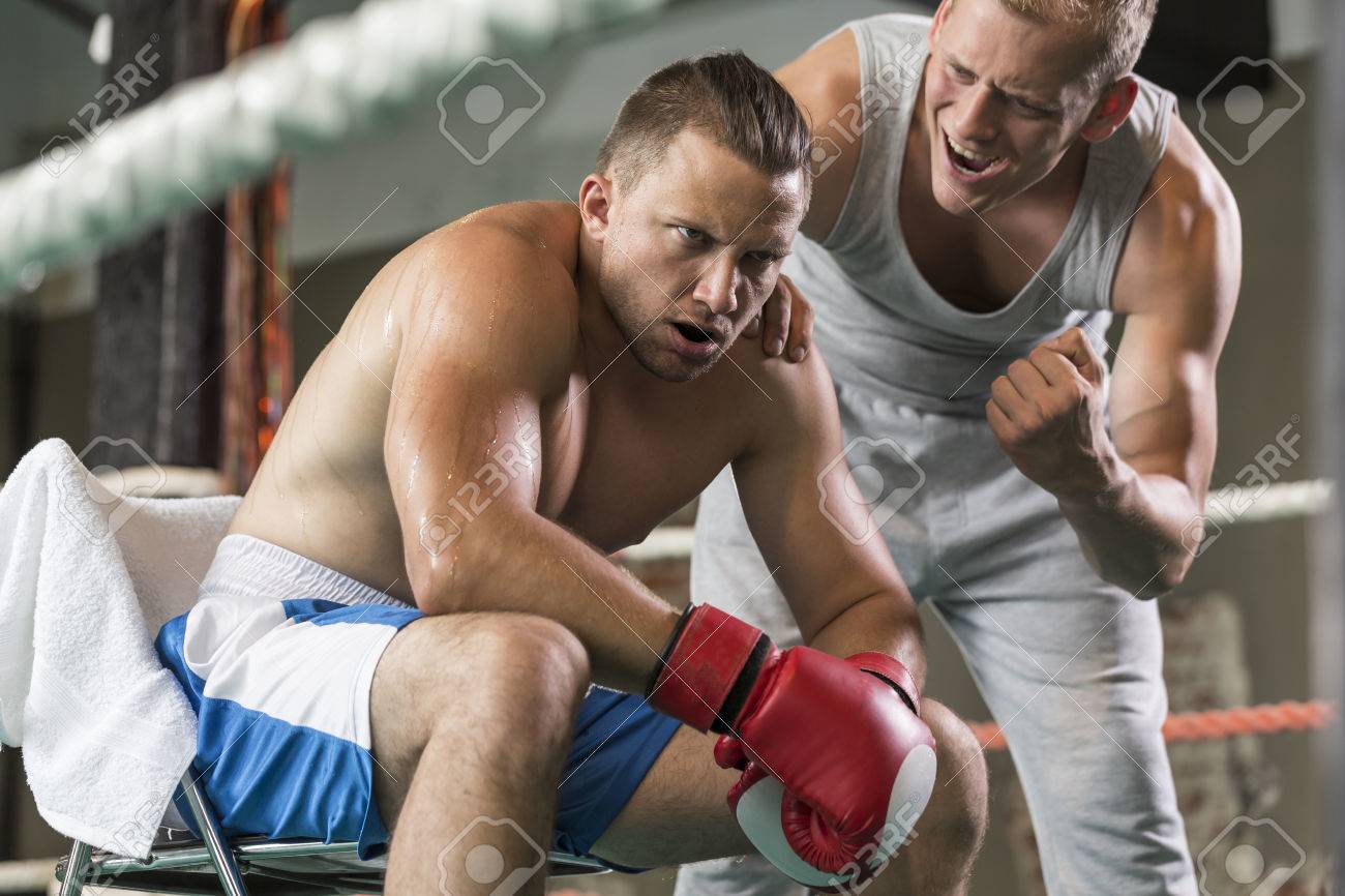 athletic coach motivating tired boxer during fight on a ring stock photo 65811358