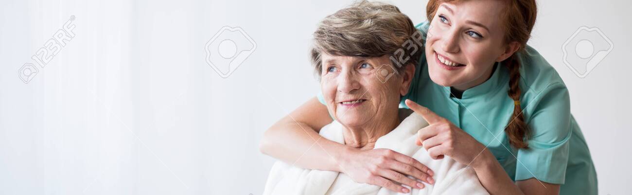 Young pretty caregiver and older happy woman - 122034843 Young pretty caregiver and older happy woman - 122034843