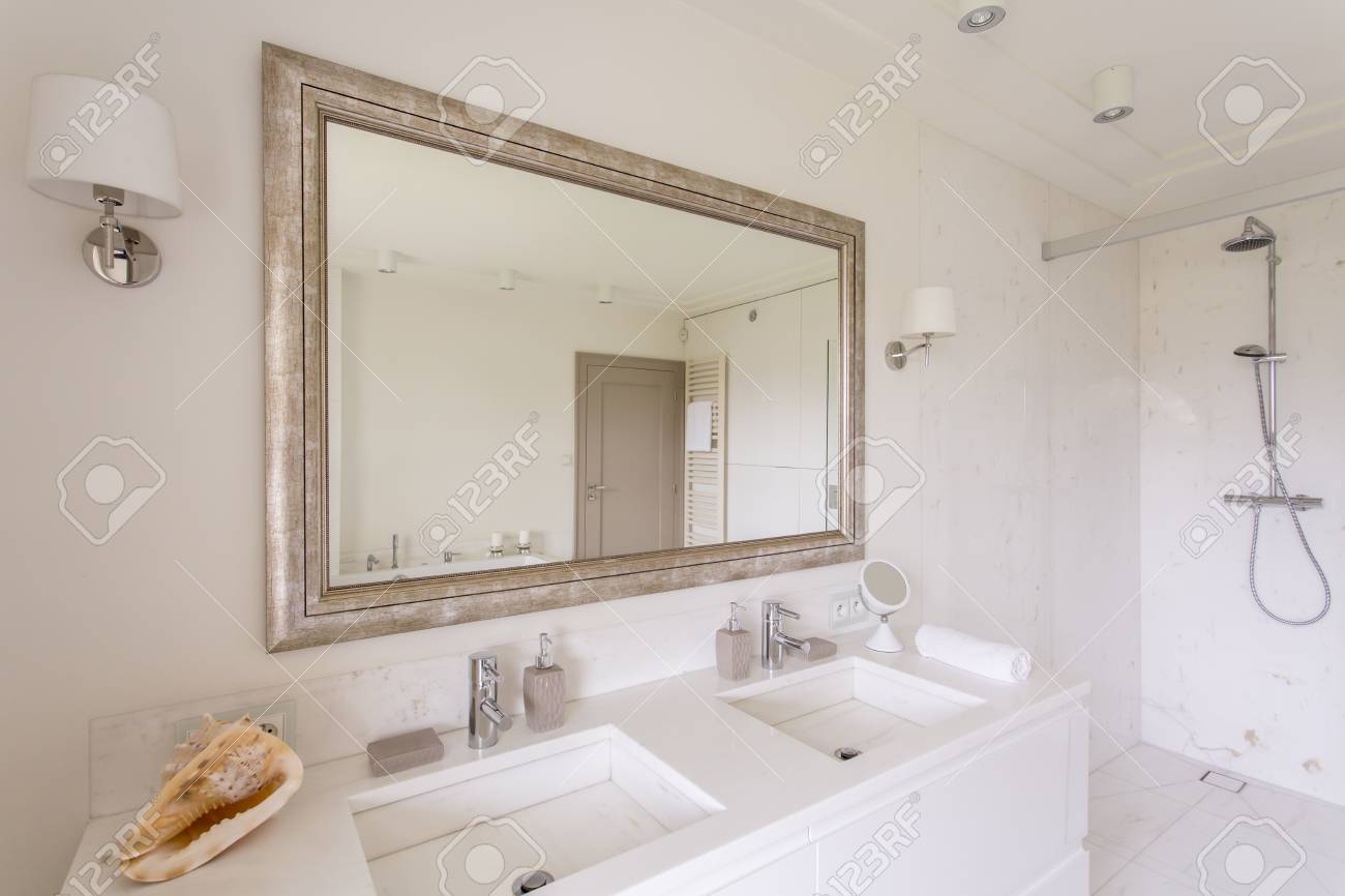 Cuarto De Baño Minimalista Con Un Gran Espejo En Un Marco Decorativo ... Cuarto De Baño Minimalista Con Un Gran Espejo En Un Marco Decorativo ...