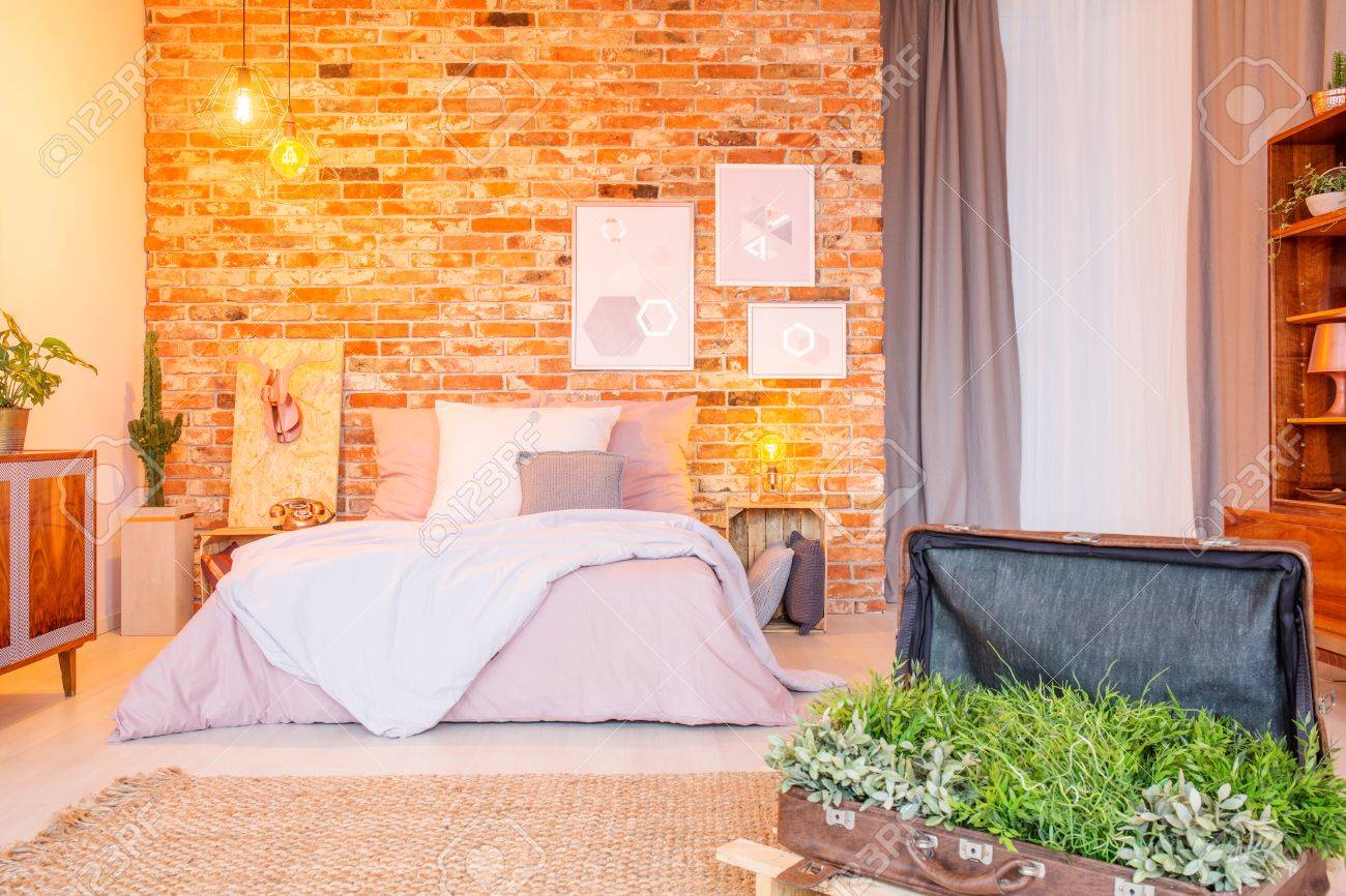 Warm Bedroom With Decorative Green Plants In Vintage Suitcase