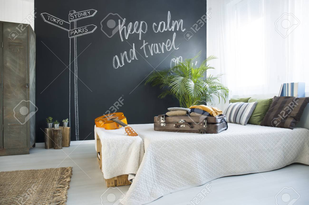 Bed In Modern Travel Themed Bedroom With Blackboard Wall