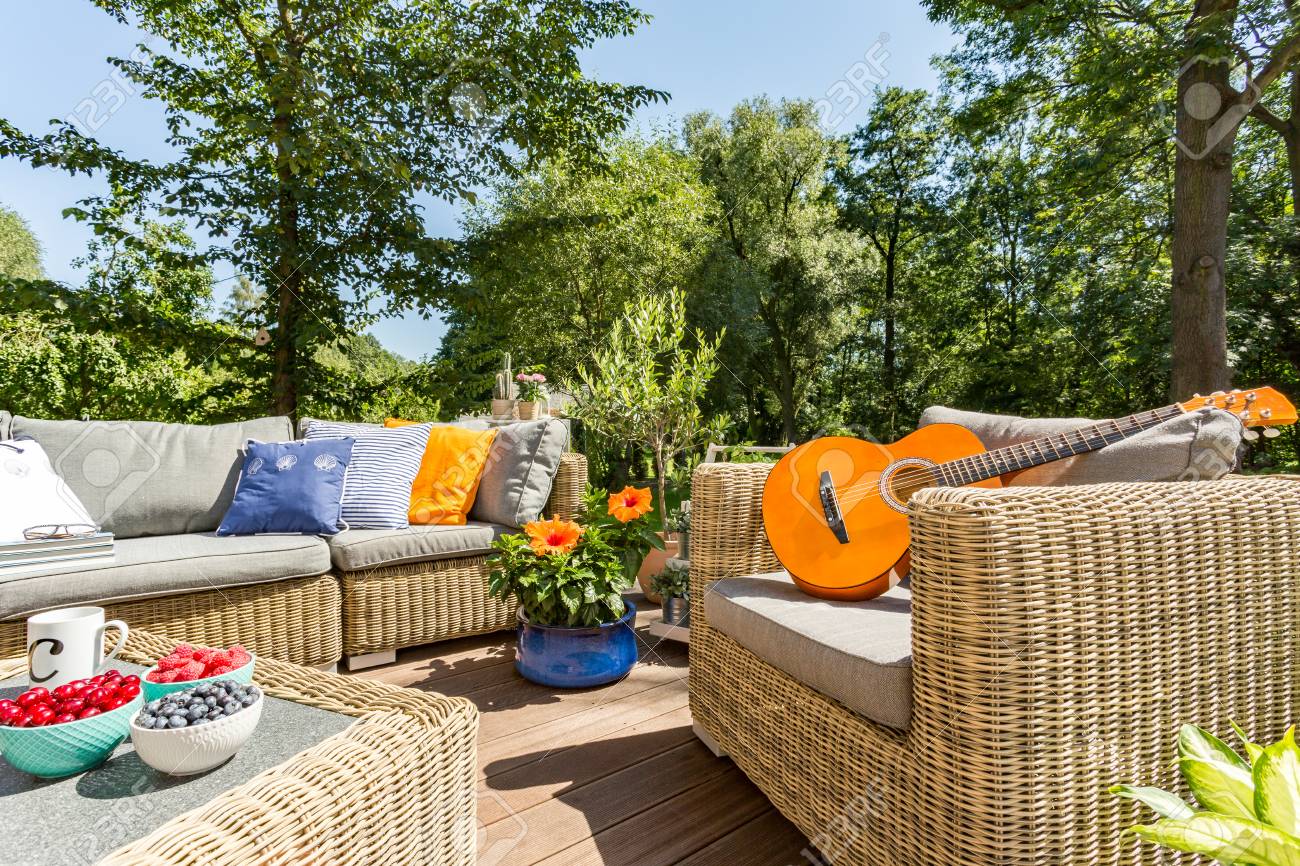 banque dimages terrasse dt avec un ensemble de meuble en rotin une guitare allonge sur un fauteuil en rotin - Meuble Terrasse banque dimages terrasse dt avec un ensemble de meuble en rotin une guitare allonge sur un fauteuil en rotin - Meuble Terrasse