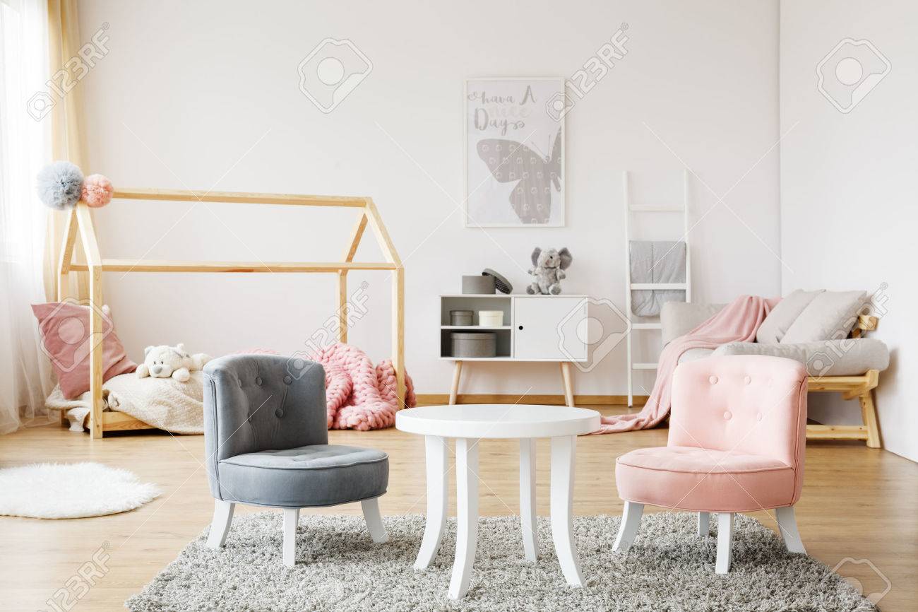 居心地の良い赤ちゃん部屋に柔らかな絨毯の上に立ってグレーとピンクの小さなかわいい椅子 の写真素材 画像素材 Image