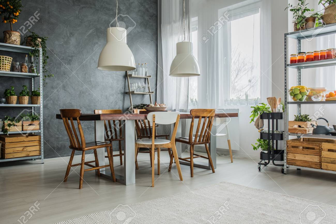 Acogedor Loft Con Mesa De Comedor, Sillas Y Estanterías De Metal ... Acogedor Loft Con Mesa De Comedor, Sillas Y Estanterías De Metal ...
