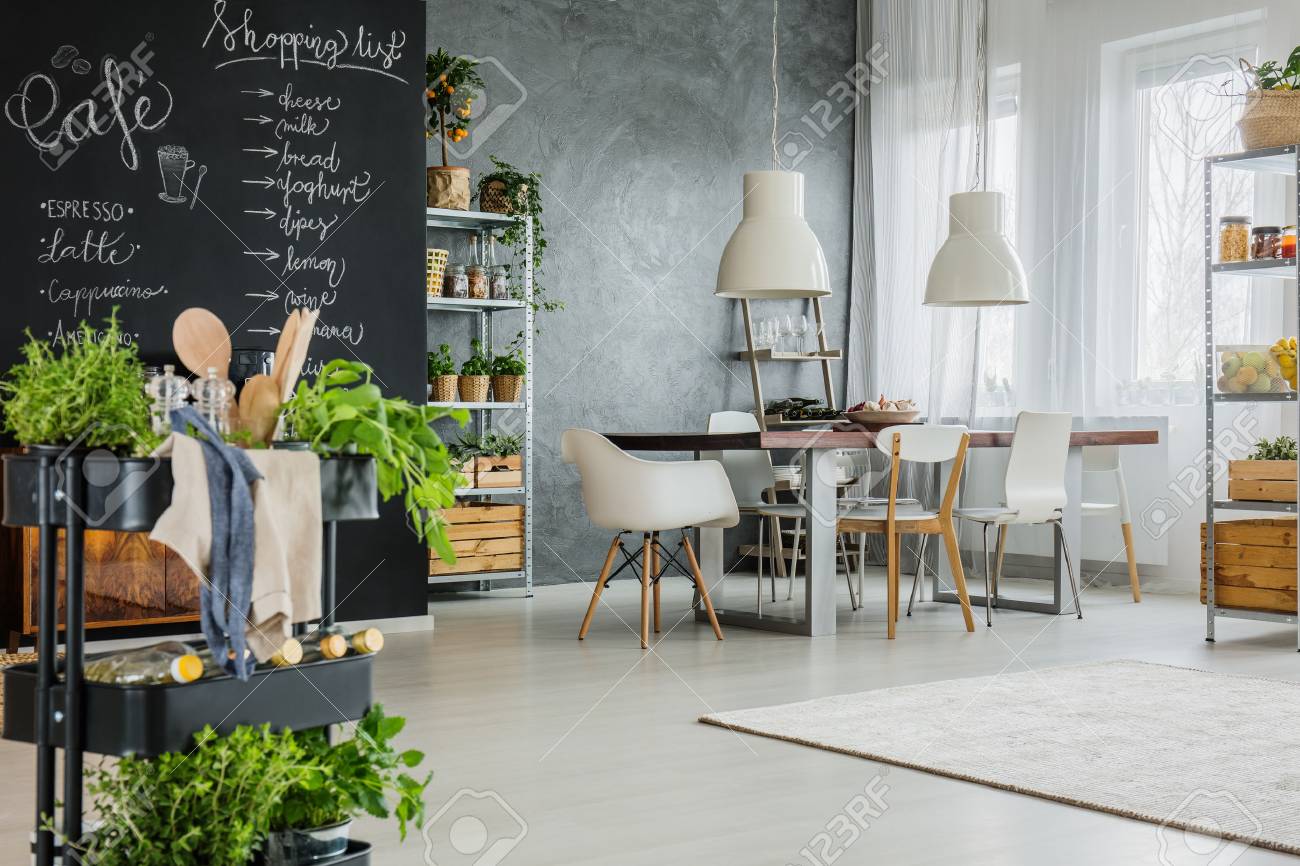 Kitchen Cart With Herbs And Chalkboard Wall In Modern Loft Stock