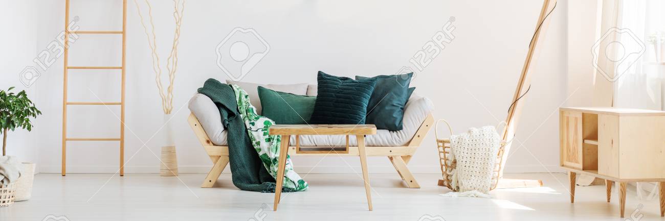 Beige Knit Blanket In Basket Next To Sofa With Moss Green Pillows Stock Photo Picture And Royalty Free Image Image 86147716