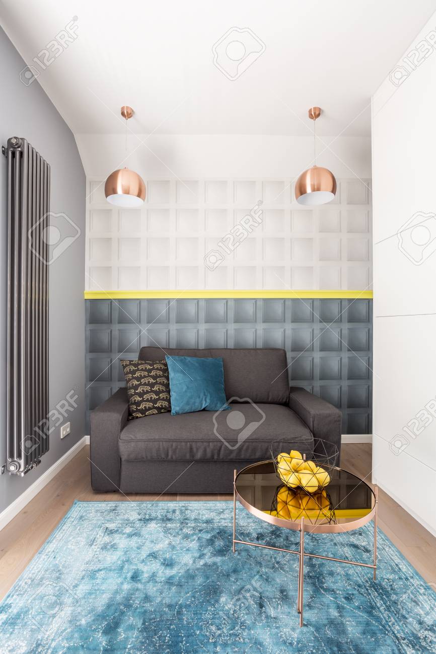 大規模な青 抽象的なカーペットとそれの上に立ってレモンのボウルと小さなテーブルのささやかな寝室のインテリア の写真素材 画像素材 Image