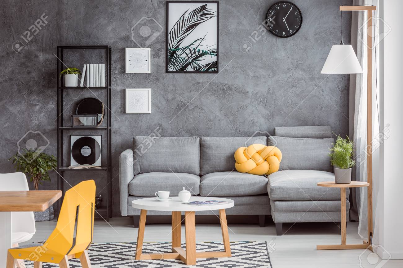 Modern Scandinavian Decor In Open Space Apartment With Textured Concrete Wall, Dining Area, Gray Couch And Yellow Accessories Stock Photo, Picture And Royalty Free Image. Image 88256225.