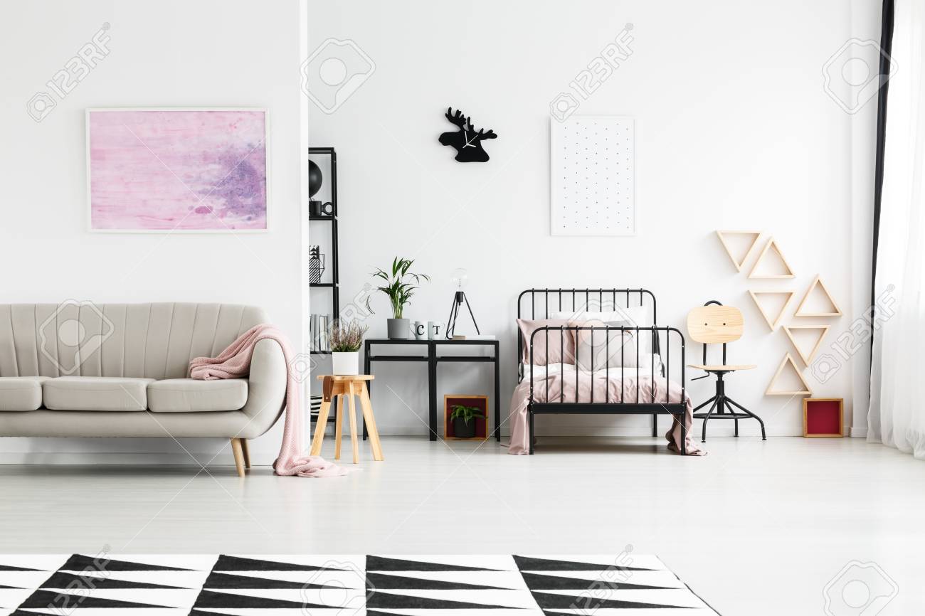 Cartel Simple Con Puntos Sobre La Cama De Metal Negro Y Un Sofa