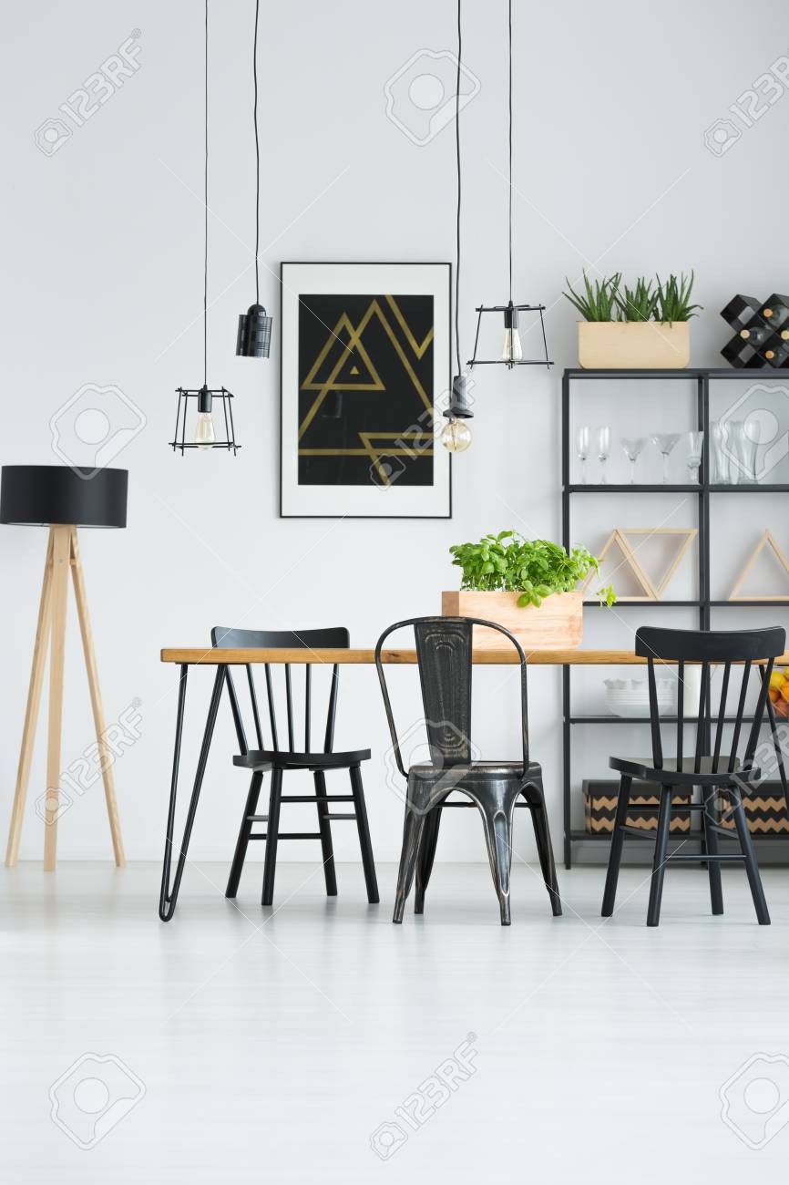 Lamps Above Dining Table With Black Chairs In Bright Interior Stock Photo Picture And Royalty Free Image Image 97990588