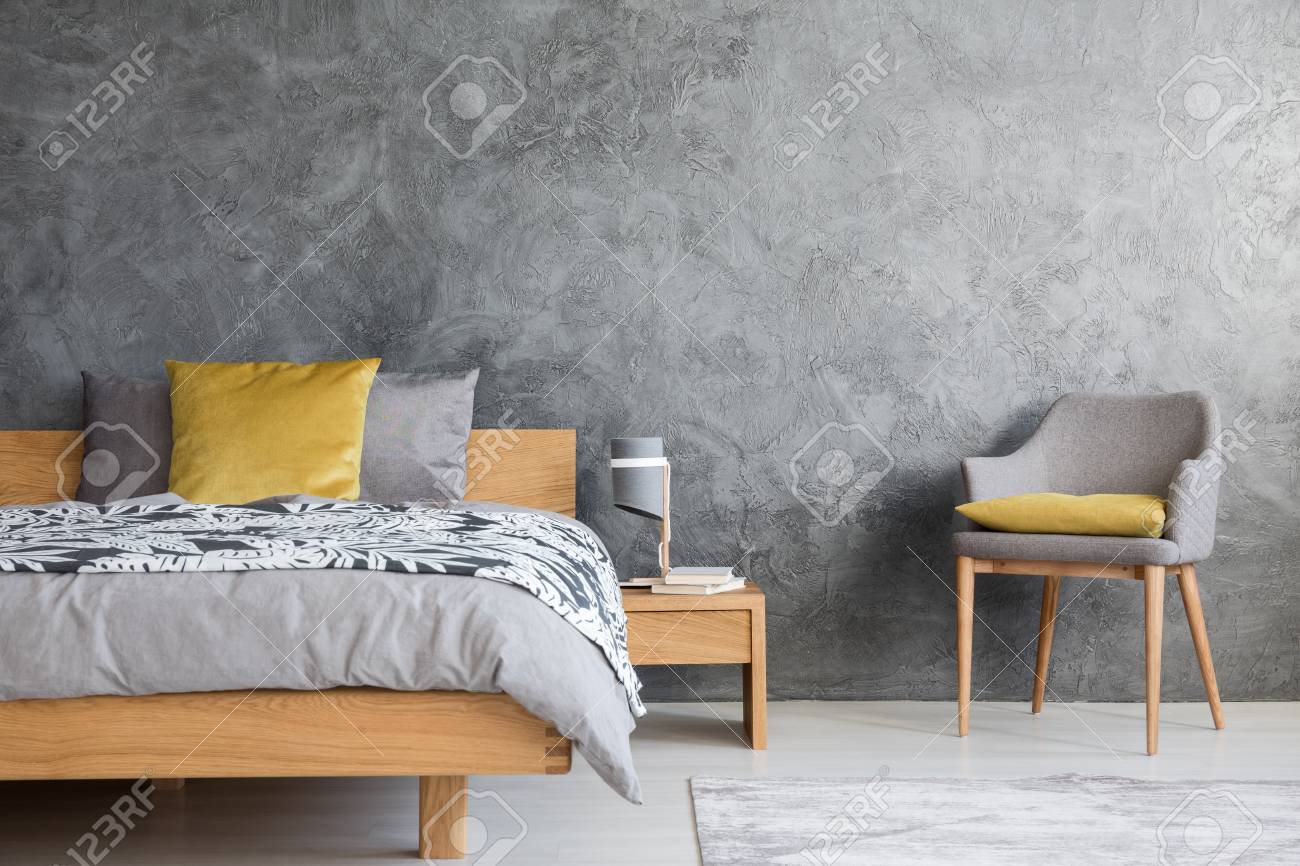 Grey Chair And Lamp On Wooden Nightstand In Dark Bedroom With Stock Photo Picture And Royalty Free Image Image 93956029