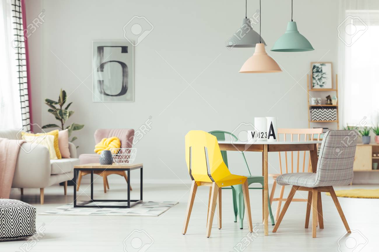 Bunte Lampen über Holztisch Und Stühle Im Gelben Wohnzimmer ... Bunte Lampen über Holztisch Und Stühle Im Gelben Wohnzimmer ...