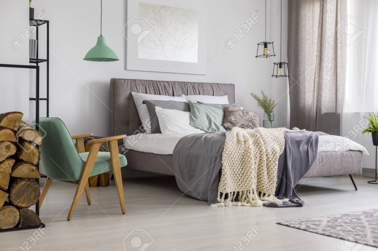 Logs Of Wood Next To Retro Green Armchair In Grey Bedroom Interior Stock Photo Picture And Royalty Free Image Image 96880043