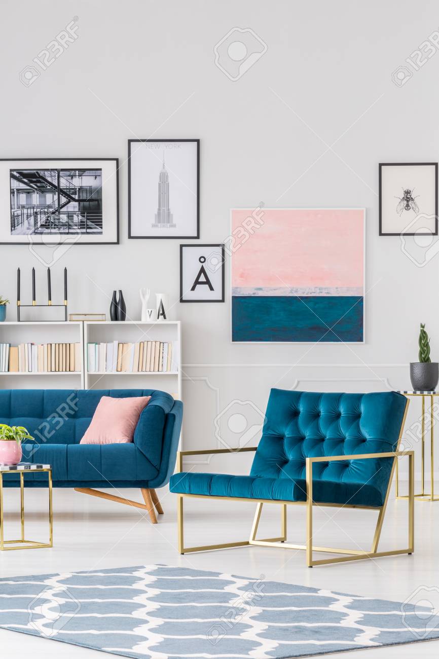白い壁にポスターのギャラリーとリビングルームのインテリアにパターンラグとネイビーブルーのアームチェア の写真素材 画像素材 Image