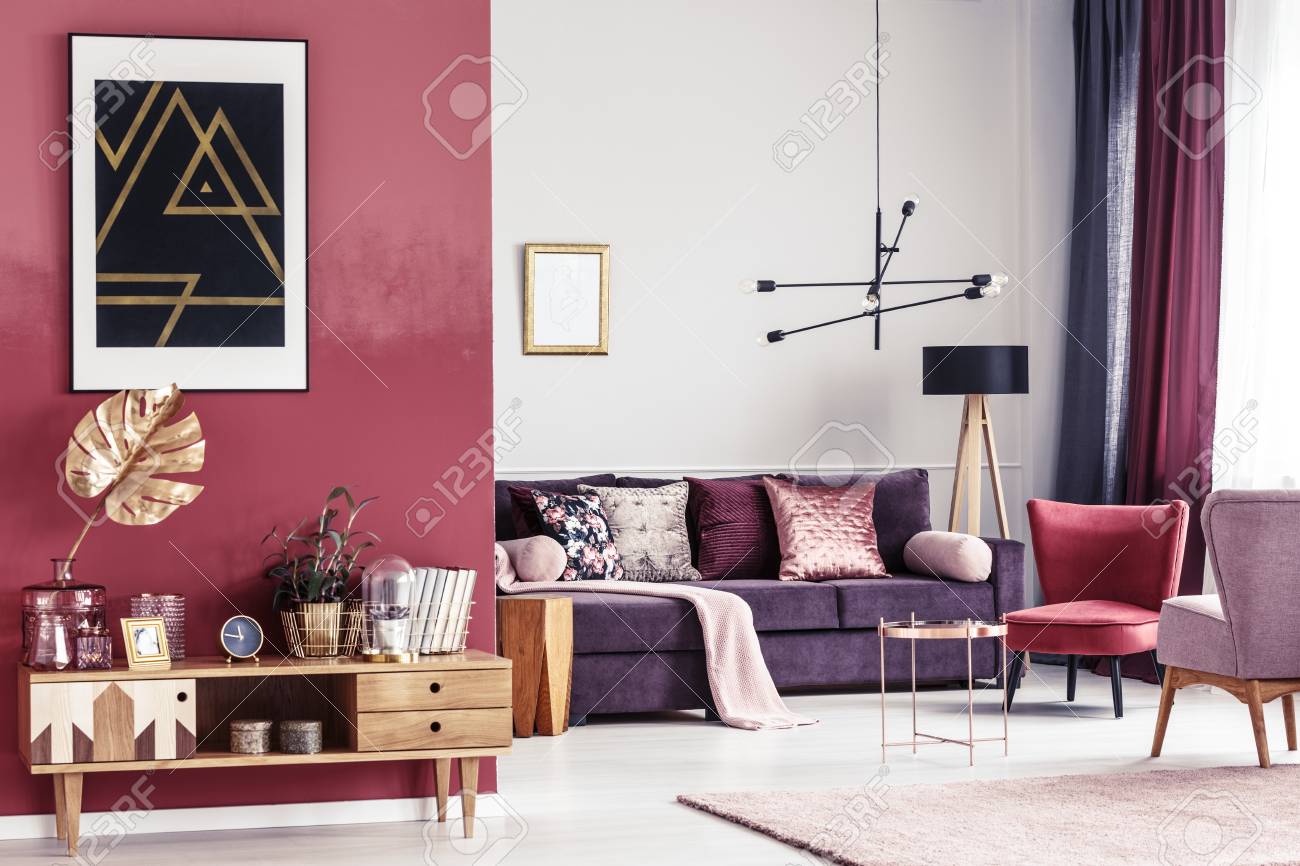 Goldblatt Auf Hölzernem Schrank Gegen Rote Wand Mit Schwarzem Plakat ... Goldblatt Auf Hölzernem Schrank Gegen Rote Wand Mit Schwarzem Plakat ...