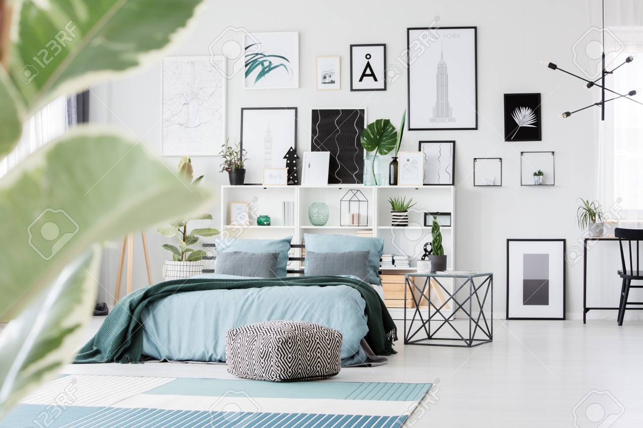 table next to bed white mirror stock photo table next to bed with green blanket against shelves and posters on the wall in bright bedroom interior next to bed with green blanket against shelves and posters table next to bed white mirror stock photo table next to bed with green blanket against shelves and posters on the wall in bright bedroom interior next to bed with green blanket against shelves and posters