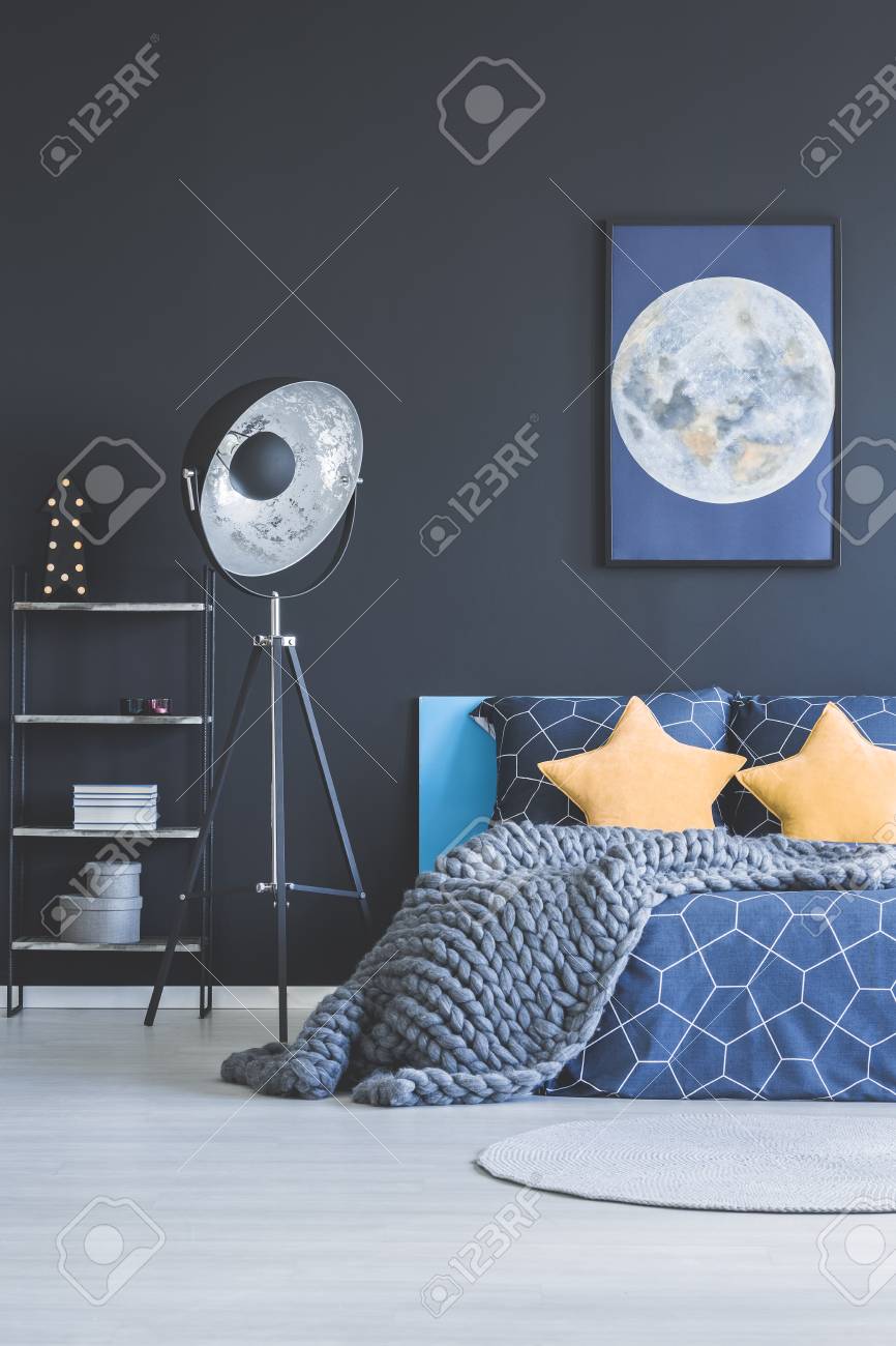 Yellow Stars Pillows And Knit Blanket On Bed In Navy Blue Bedroom