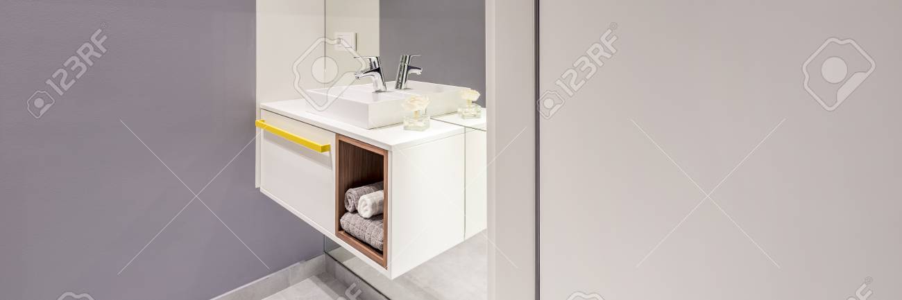 Side View Of Modern Washbasin With A Cabinet And Towels Next