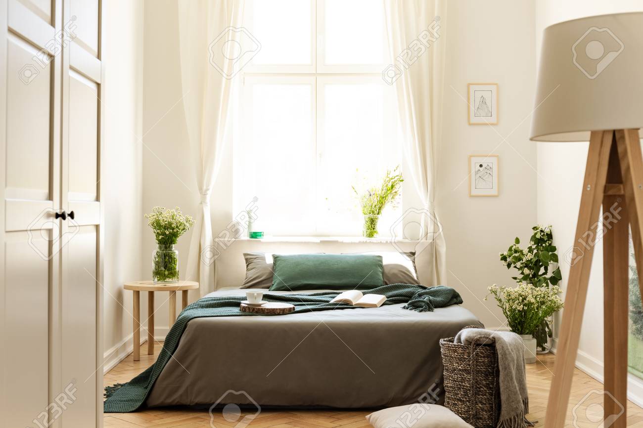 Lamp And White Door In Bright Bedroom Interior With Plants And