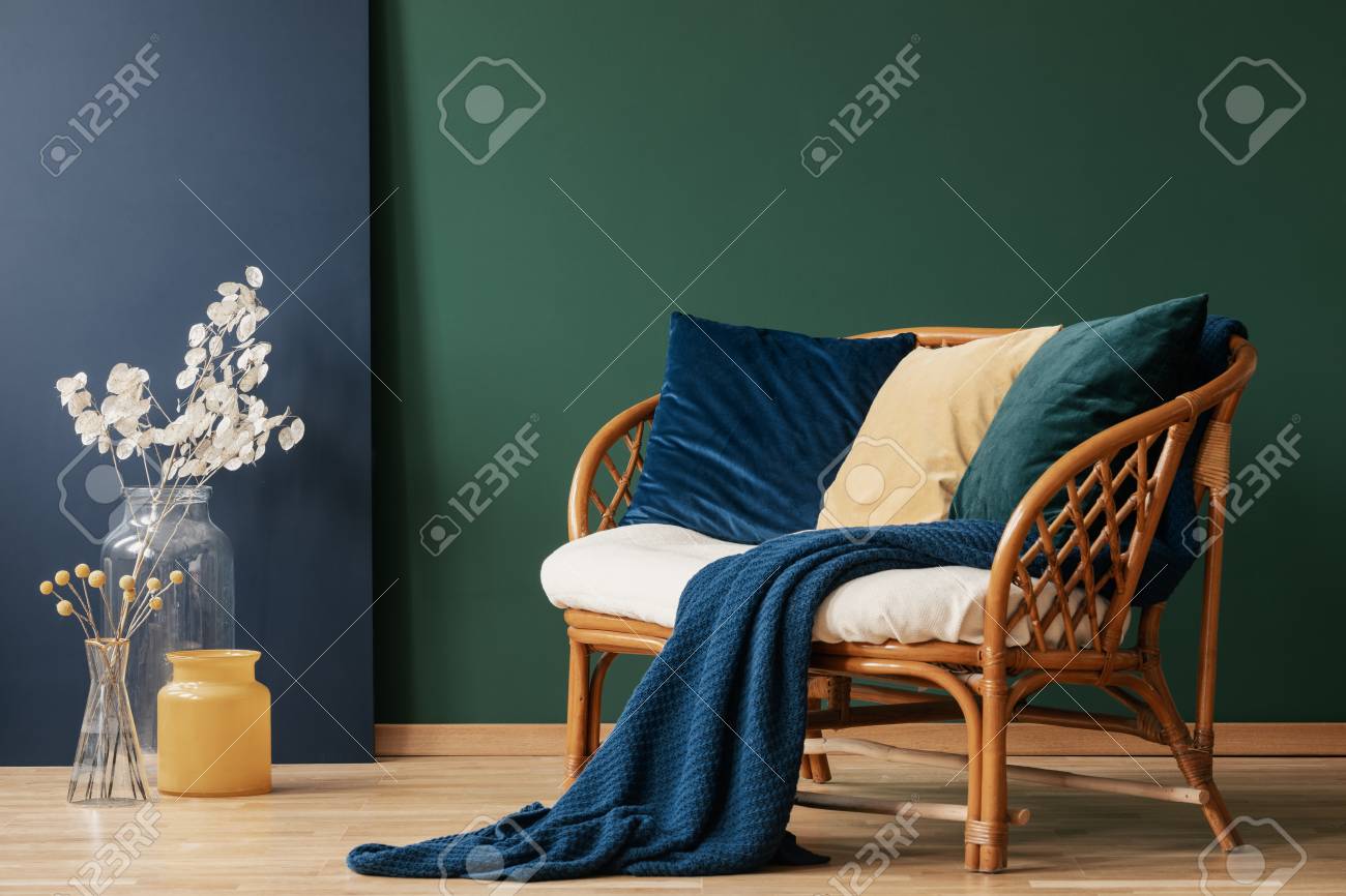 Glass Vases With Flowers Next To Comfortable Rattan Settee With