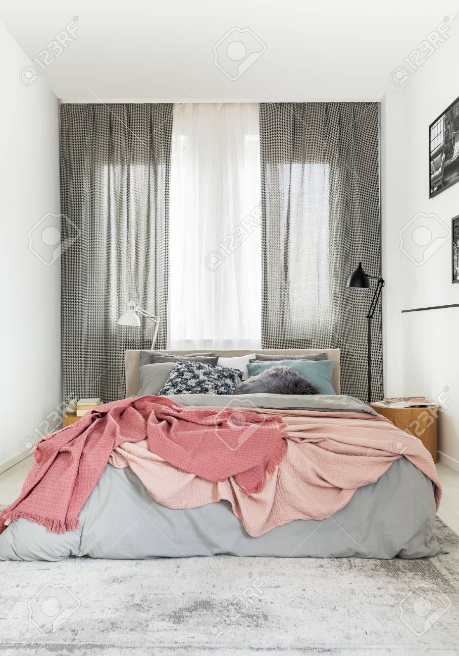 Cozy King Size Bed With Grey Bedding And Warm Pastel Pink Blanket