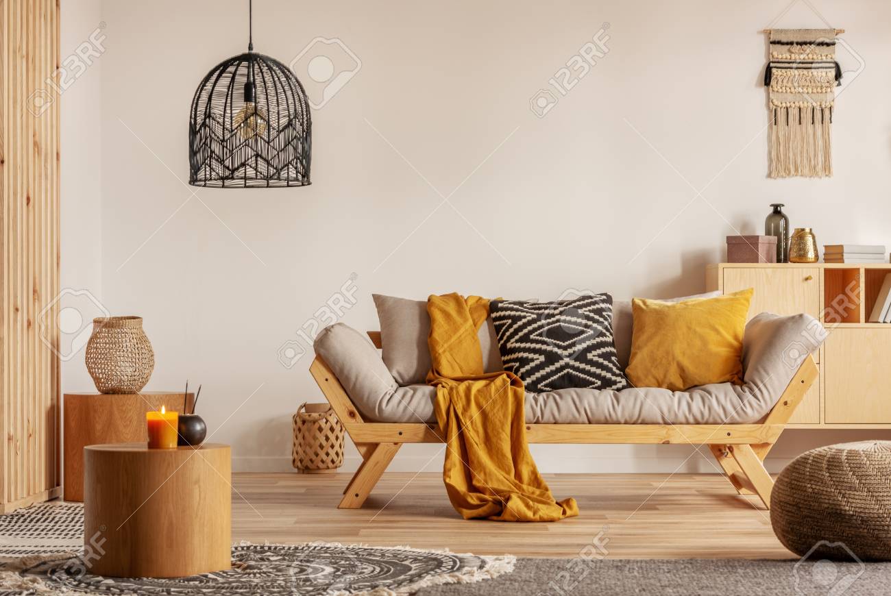 Scandinavian sofa with pillows and dark yellow blanket in bright living room interior with black chandelier - 118480869 Scandinavian sofa with pillows and dark yellow blanket in bright living room interior with black chandelier - 118480869
