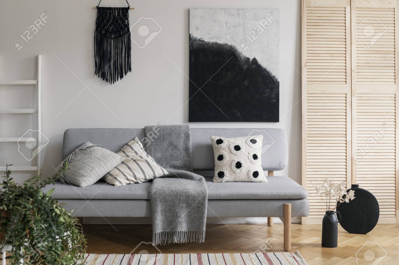 Black Handmade Macrame And Fancy Painting On White Wall Of Sophisticated Living Room Interior With Grey Fashionable Couch With Pillows And Cozy Blanket Stock Photo Picture And Royalty Free Image Image 120221878