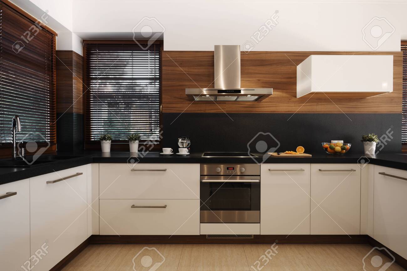 Elegant white and black kitchen with wooden accents and silver oven and sink - 124428544 Elegant white and black kitchen with wooden accents and silver oven and sink - 124428544