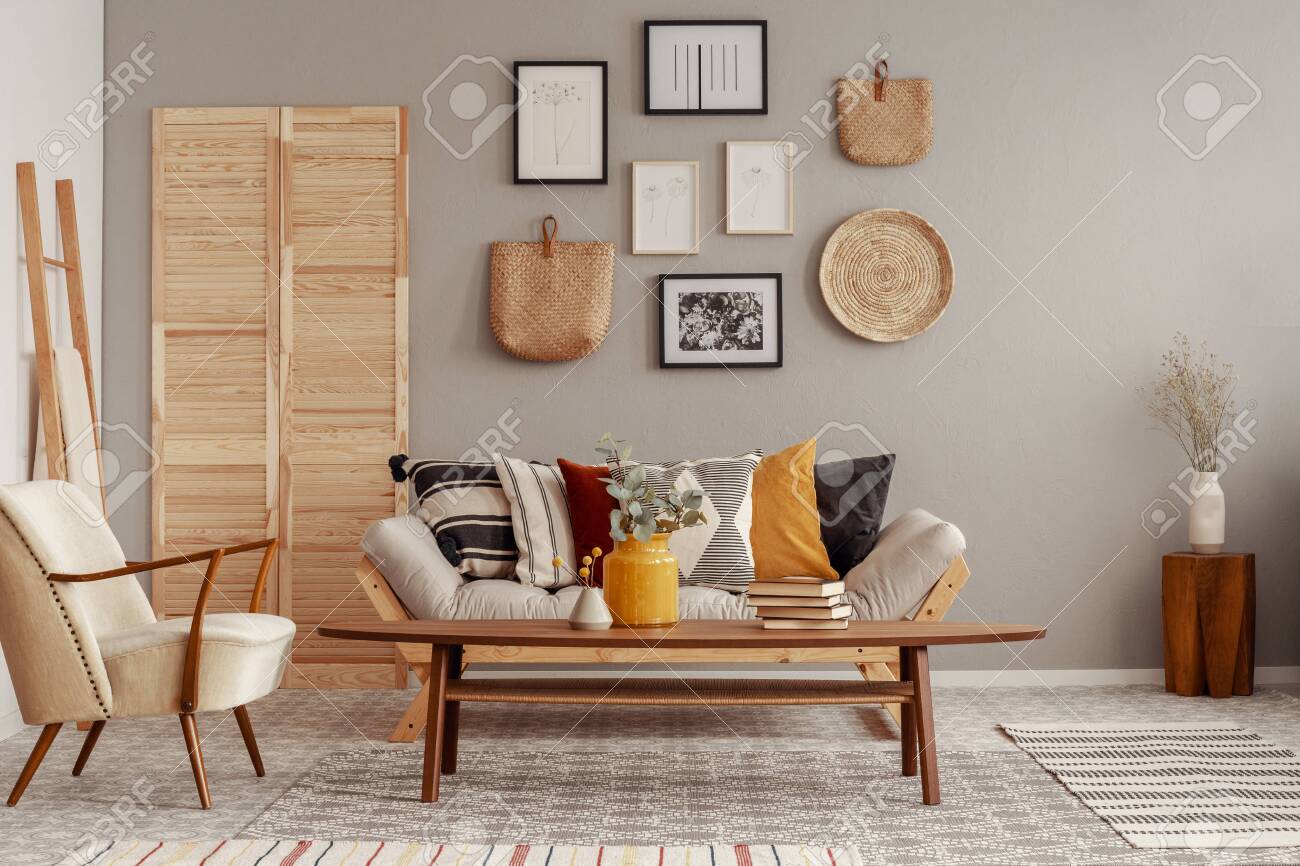 Trendy creme colored armchair in Scandinavian living room interior with gallery of posters on beige wall - 129347479 Trendy creme colored armchair in Scandinavian living room interior with gallery of posters on beige wall - 129347479