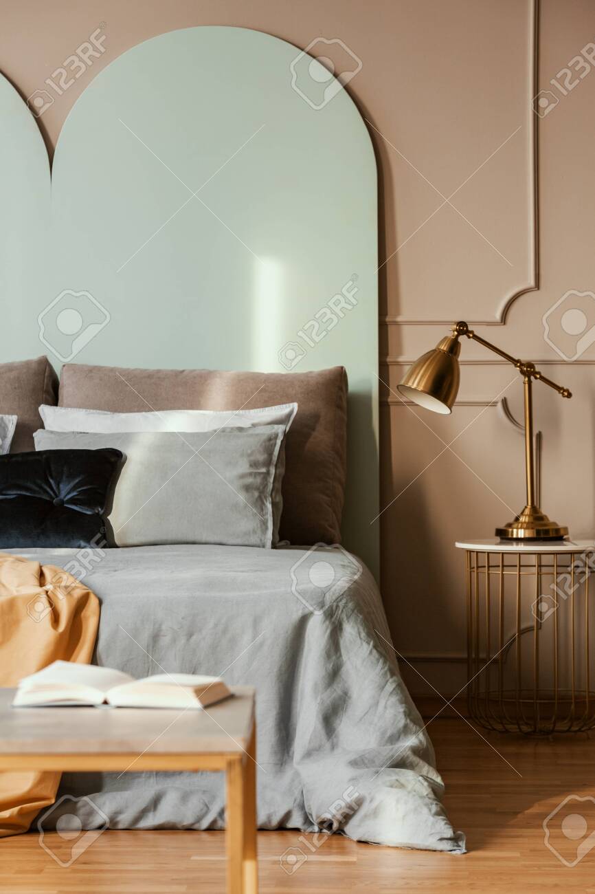Golden Lamp On Modern Nightstand Table Next To Blue Bed In Grey Stock Photo Picture And Royalty Free Image Image 129348118