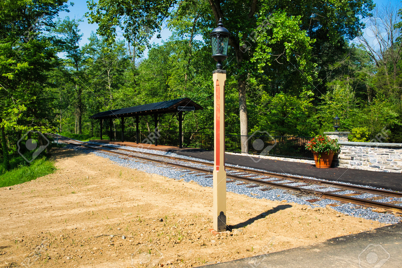 A Small Train Station Waiting for Passengers and a Train - 165159403 A Small Train Station Waiting for Passengers and a Train - 165159403