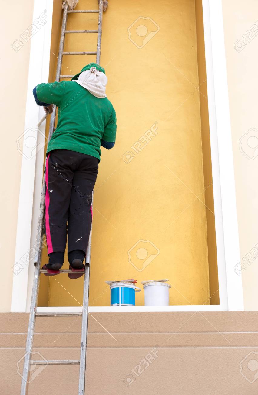 Pintor En Una Escalera Pintando La Pared Durante La Renovacion