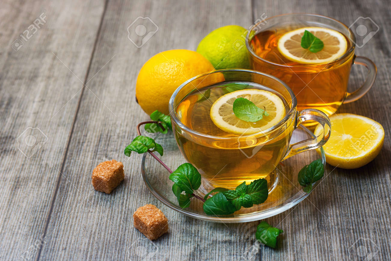 Two Glass tea Cup's with lemon, lime and mint on gray wooden background. - 166379173 Two Glass tea Cup's with lemon, lime and mint on gray wooden background. - 166379173
