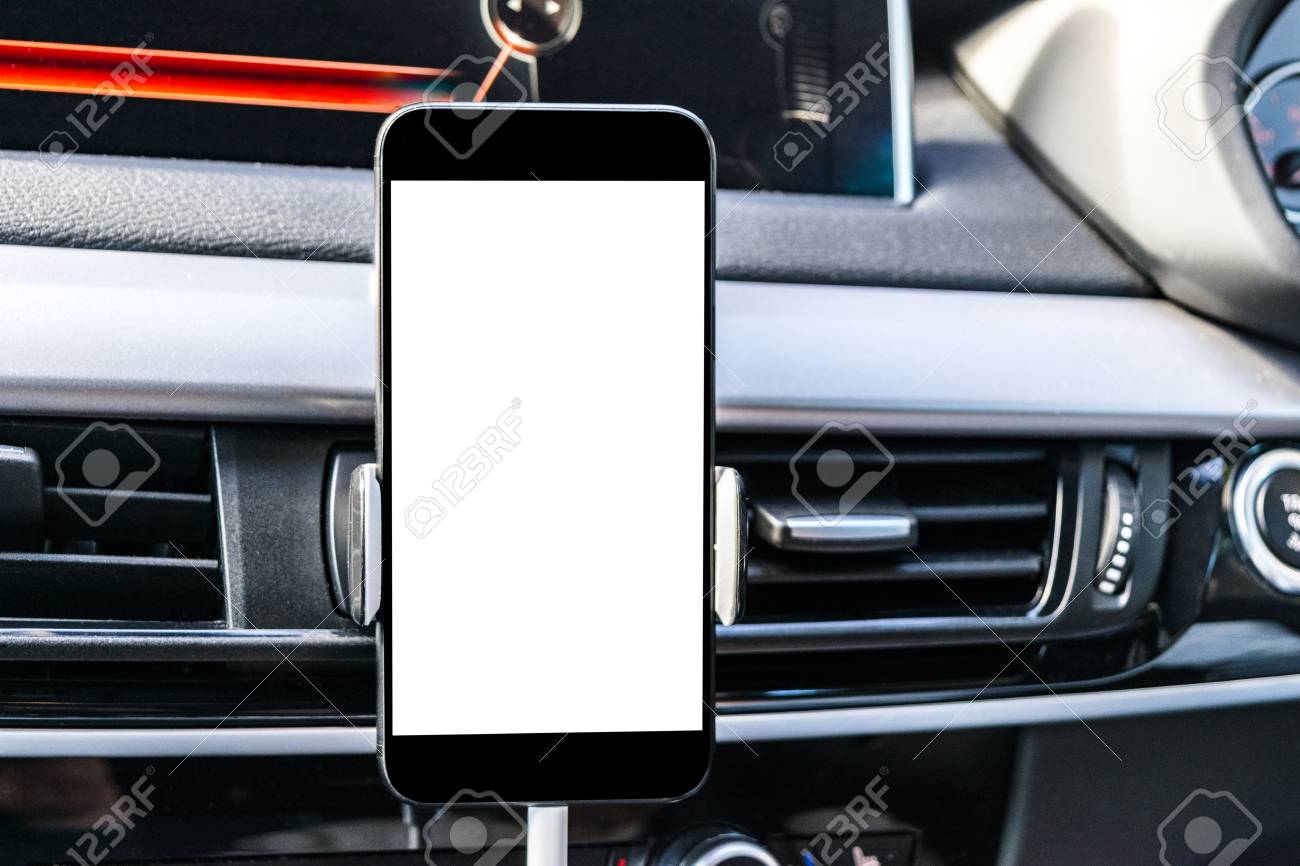 ナビゲートやgpsのための車の中でスマートフォン ホルダーにスマートフォンで車を運転 隔離された白い画面を持つ携帯 電話 空白の画面 スペースをコピーします テキスト用の空き領域 近代的な車のインテリアの詳細 の写真素材 画像素材 Image
