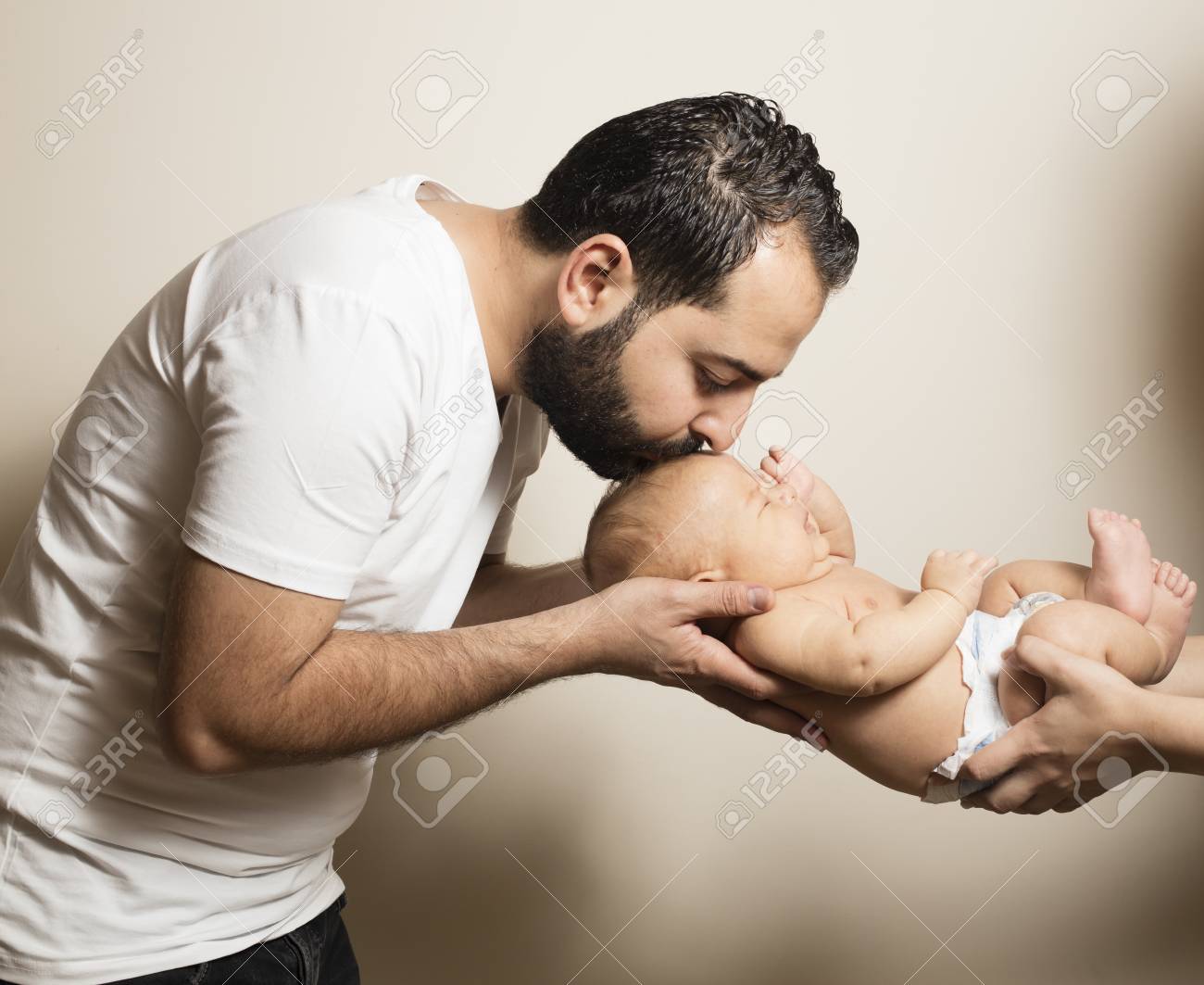 若いお父さん彼の生まれたばかりの赤ちゃんの頭にキス の写真素材 画像素材 Image