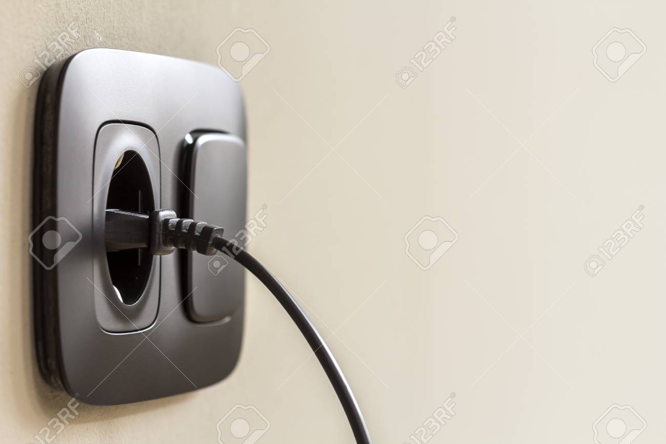 白い漆喰壁にヨーロッパの壁のコンセントに差し込まれているブラック電源コード ケーブル の写真素材 画像素材 Image