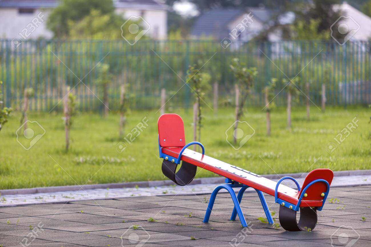 Seesaw Swing In Big Yard With Soft Rubber Flooring On Sunny Summer