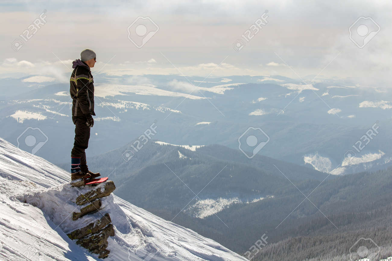 Silhouette of alone tourist standing on snowy mountain top enjoying view and achievement on bright sunny winter day. Adventure, outdoors activities and healthy lifestyle concept. - 135229500 Silhouette of alone tourist standing on snowy mountain top enjoying view and achievement on bright sunny winter day. Adventure, outdoors activities and healthy lifestyle concept. - 135229500