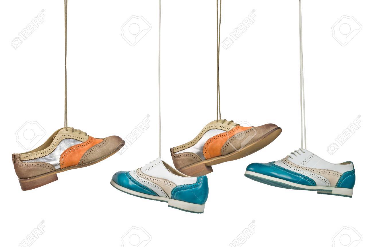 Nice woman color shoes hanging on laces on isolated white background