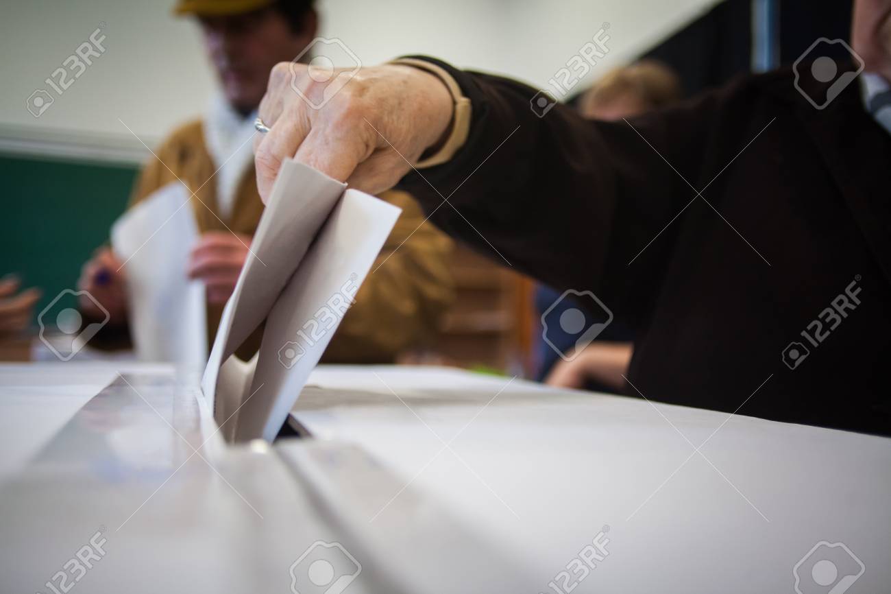 Bureaux De Vote Pour Les Legislatives : Une personne dépose son bulletin de vote lors du vote pour les