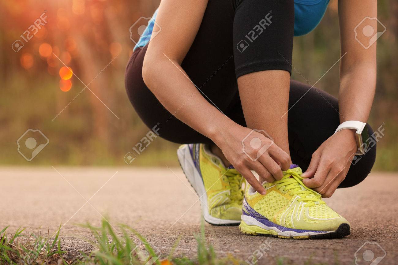 woman tying sport shoes ready for run - 52677872