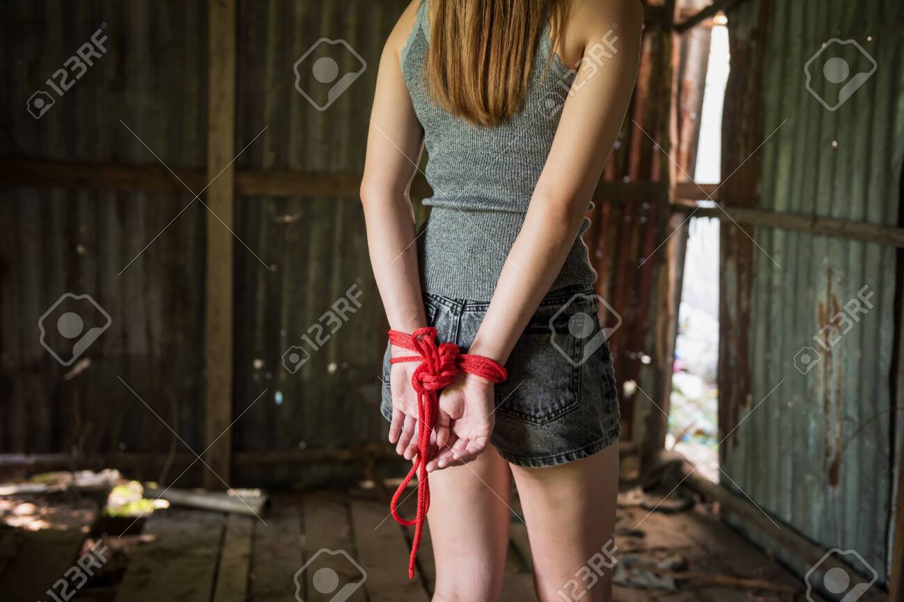 Hostage Girl Hands Tied By Red Rope In Abandon House. Victim Woman  Kidnapping Concept From Terrorist. Sexual Abuse Or Rape In Dirty Room With  Copy Space For Text. Stock Photo, Picture and