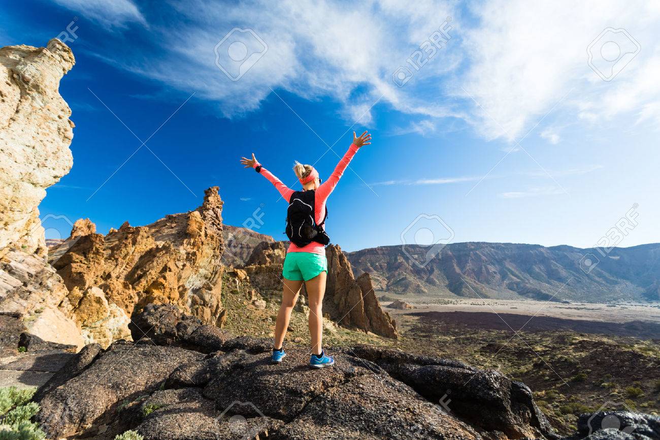 Woman hiker with arms outstretched in mountains. Beauty female runner, hands up and enjoy inspirational landscape on rocky trail footpath on Tenerife, Canary Islands - 52342258 Woman hiker with arms outstretched in mountains. Beauty female runner, hands up and enjoy inspirational landscape on rocky trail footpath on Tenerife, Canary Islands - 52342258