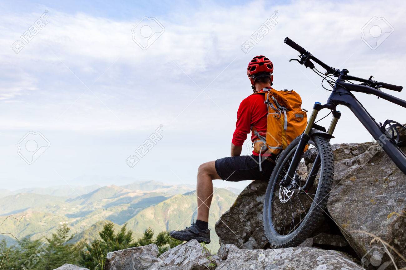Mountain biker looking at view on bike trail in autumn mountains. Rider cycling on single track. Sport fitness, motivation and inspiration in beautiful inspirational landscape. - 56697774 Mountain biker looking at view on bike trail in autumn mountains. Rider cycling on single track. Sport fitness, motivation and inspiration in beautiful inspirational landscape. - 56697774