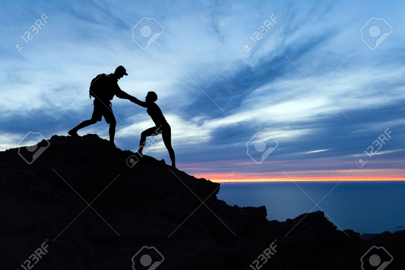 Teamwork couple hiking, help each other, trust assistance and silhouette in mountains, sunset over ocean. Team of climbers man and woman helping hand on mountain top, inspirational climbing team. - 64040362 Teamwork couple hiking, help each other, trust assistance and silhouette in mountains, sunset over ocean. Team of climbers man and woman helping hand on mountain top, inspirational climbing team. - 64040362