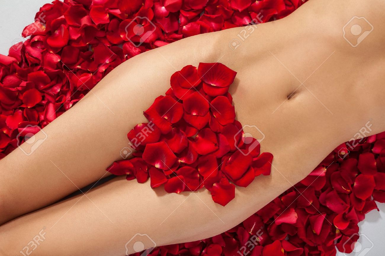 hermoso cuerpo de la mujer en contra de pétalos de rosas rojas
