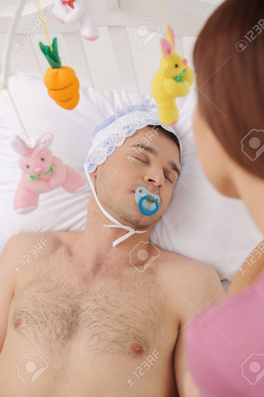 Big Bebe Dans Son Lit Vue De Dessus D Homme Adulte Enfant Couchee Sur Le Lit De Bebe Tandis Que Le Jeune Femme Qui Cherche A Lui Banque D Images Et Photos Libres De